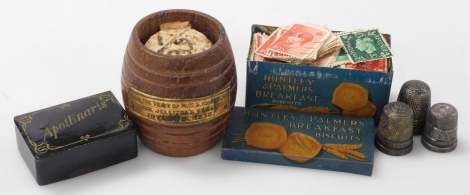 A group of collectables, comprising a match holder of barrel form, from the teak of HMS Iron Duke, Admiral Jellicoe's Flagship, Jutland 1916, three silver thimbles, papier mache snuff box with 'Apollinaris' to the lid, and a small Huntley & Palmers Breakf