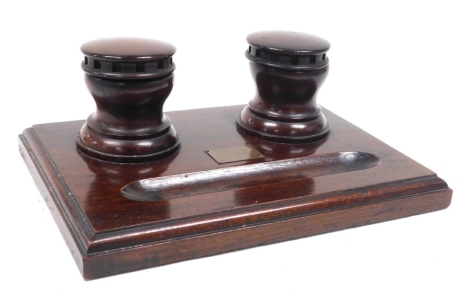 A World War One Naval oak desk stand, with a pair of hinged lidded capstan shaped inkwells, bears plaque centrally for "HMS Lion", Heligoland, Doggerbank, Jutland, 1914-1918, 28cm wide.