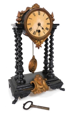 A late 19thC French cast iron and tin portico clock, circular white dial bearing Roman numerals, thirty hour movement, the black case applied with copper flowers to the bowl and a mask to the base, raised on paw feet, with pendulum and key, 29cm high.