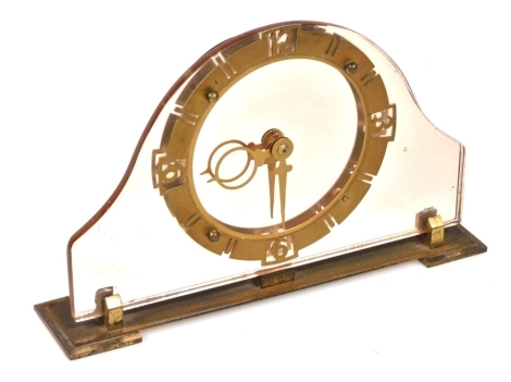 An Art Deco pink glass fronted mantel clock, with a circular brass dial bearing Arabic numerals at quarters, stylised hands, clockwork movement, the case of Napoleon hat form, 23.5cm wide