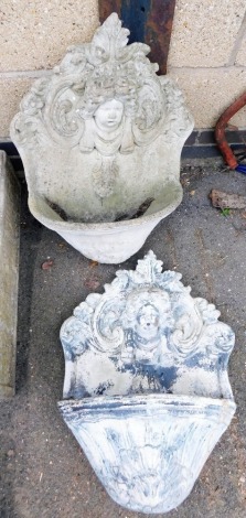 A pair of composition garden wall fonts, the top carved with figures of children amongst scrolls and flowers, each 72cm high.