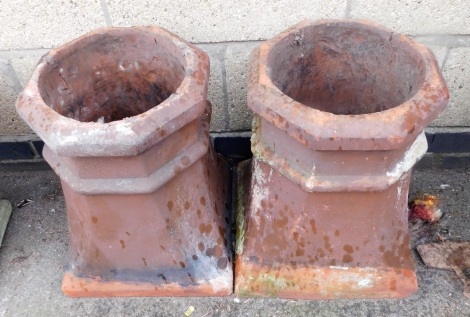 A pair of terracotta chimney stacks, each top of shaped with a outswept square base, each 46cm high.