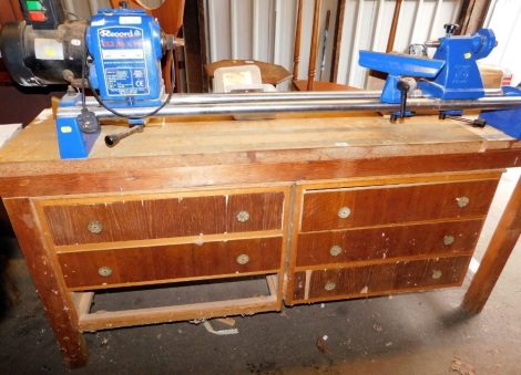 A Record spindle lathe CL23 36X18, mounted on a wooden bench, base with various drawers, 177cm wide.