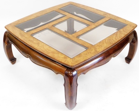 An oak and burr oak coffee table, the top inset with an arrangement of rectangular and square glass panels, raised on curved shaped legs connected by shaped aprons, 43cm high, the top 97cm x 97cm.