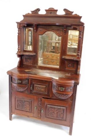 A Victorian mahogany mirror back sideboard, with a foliate carved broken neck pediment, triple bevelled mirror back with shaped shelves supported on turned and fluted columns, over a straight and serpentine fronted base, with two bow fronted drawers flank