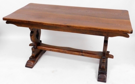 An oak two plank refectory table, raised on shaped end supports united by a stretcher, 79cm high, 153cm wide, 75cm deep.