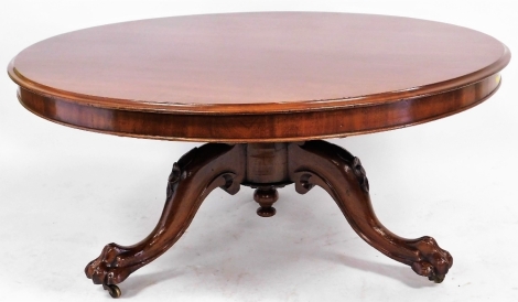 A Victorian mahogany circular tilt top breakfast table, cut down to a coffee table, raised on a partially turned column over three cabriole legs terminating in lion's paw feet, on castors, 56cm high 122cm wide.