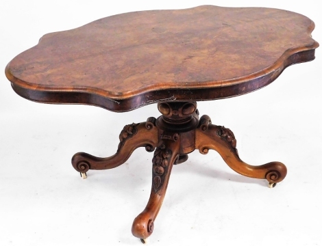 A Victorian serpentine walnut tilt top breakfast table, raised on a turned and carved column over four fruit and foliate carved cabriole legs, 77cm high, 144cm wide, 106cm deep.