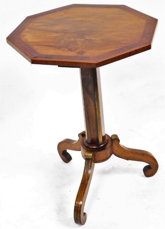 An early Victorian walnut and rosewood cross banded octagonal occasional table, raised on a square and brass mounted channelled column, over three brass capped scroll legs, 72cm high, 48cm wide.