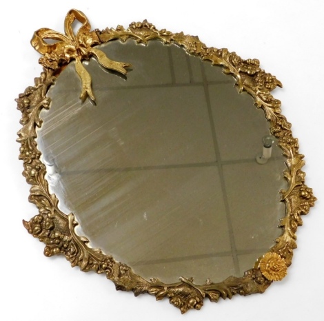 An early 20thC brass framed oval wall mirror, cast with a bow, fruit, and scrolling leaves, 58cm high, 50cm wide.