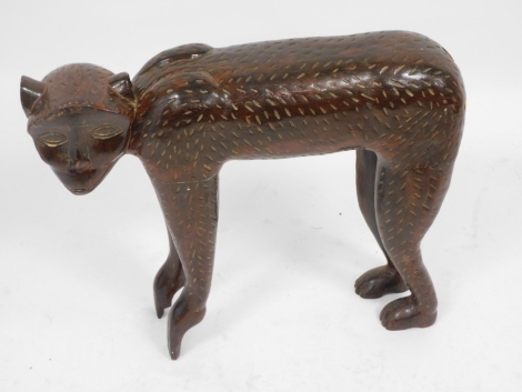 An African carved figure of a standing monkey, 53cm high, 63cm wide.