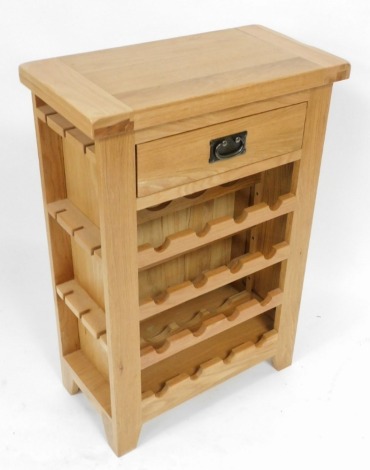 A light oak wine rack, with a frieze drawer, over sixteen bottle recesses, raised on stiles, 90cm high, 62cm wide, 32cm deep.