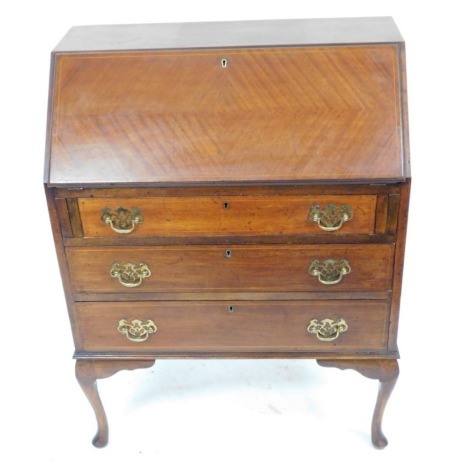 An Edwardian mahogany bureau, with boxwood line inlay, the fall flap opening to reveal a central drawer and six recesses, over three long graduated drawers, raised on cabriole legs, 99cm high, 74.5cm wide, 41cm deep.