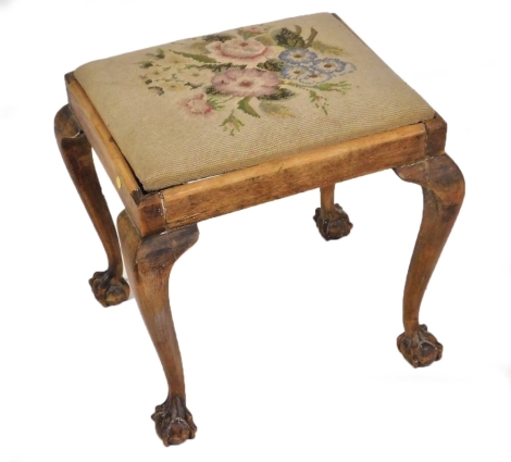 A 19thC mahogany stool, with a floral wool work seat, raised on cabriole legs, on ball and claw feet, 50cm wide.