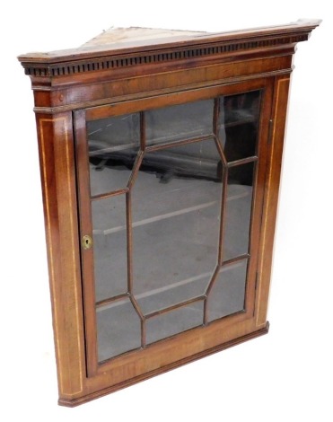 A George III mahogany and inlaid hanging corner cabinet, the top with a moulded edge above dentil moulding, with an astragal glazed door enclosing three shelves, 94cm high, 72cm wide, 40cm deep.