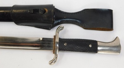 A German dagger, with knurled hand grip, fullered blade, 25cm long, steel scabbard with leather belt hanger, 40cm overall length. - 2