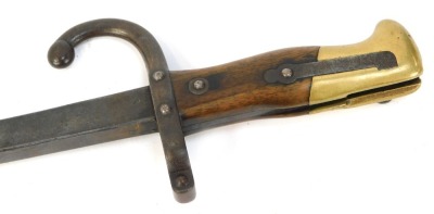 A French St Etienne bayonet, with a walnut and brass handle, with curved hoop stamped FH22471, blade engraved and dated 1879, 65cm long.