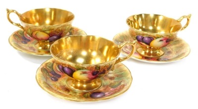 A set of three Aynsley Orchard Gold pattern tea cups and saucers, each painted with fruit by N Brunt,with a gold lustre internal finish, with green stamp to underside, the saucers 15cm diameter, the cups 6cm high. (6)