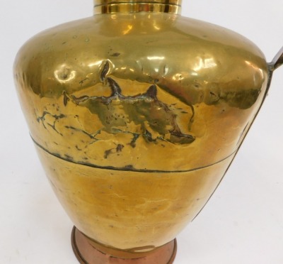 A 19thC brass lidded flagon, with a formed handle and strap top, on a copper foot, 70cm high. (AF) - 3