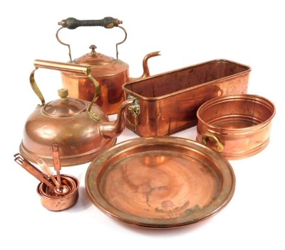 A Victorian copper kettle, further kettle, pair of salvers, two planters, graduated set of seven measuring spoons.