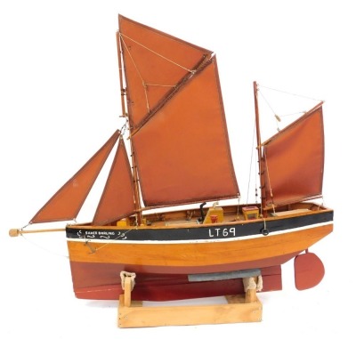 A wooden scale model of a traditional fishing boat, Silver Darling, Lowestoft, with fully rigged sales and a fitted deck, raised on a wooden stand, 118cm wide.