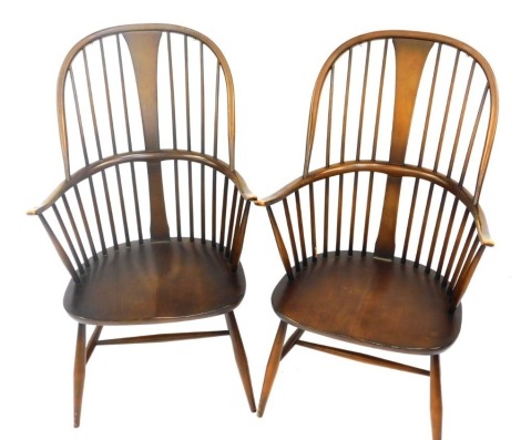 A pair of Ercol mid brown stained ash and elm Windsor armchairs, each with spindle turned back, solid seat, on H stretcher.