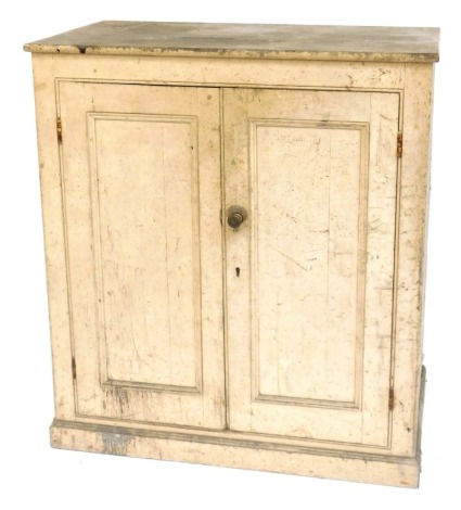 A cream painted pine cupboard, with two panelled doors on a plinth, 122cm high, 110cm wide, 59cm deep.