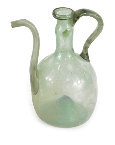 A blown glass jug, possibly 18thC, with a handle and shaped spout, with inverted base, green in colour, 24cm high. (AF)