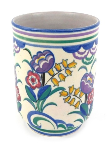 An early 20thC Poole, Carter Stabler Adams, pottery vase, of cylindrical form, painted with flowers, impressed marks, 17cm high, 12cm diameter.