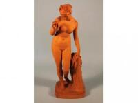 A Copenhagen Eneret terracotta figure of a female nude holding an apple beside a pedestal