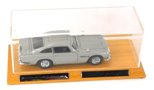 A Danbury Mint 1:25 scale model of the 1964 James Bond 007 Aston Martin DB5, serial number B4604, oak stand and Perspex cover, 29cm wide overall, and two certificates of authenticity, numbers B4604 and B4125.