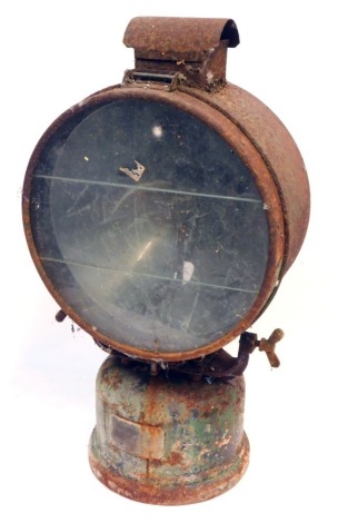 A railway inspection lamp, with metal casing on a mounted base, with three sectional glass plate and rubbed stamps, 65cm high, 36cm diameter, 25cm deep. (AF)