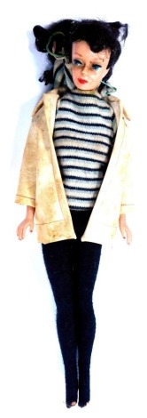 A 1960's barbie doll, with tights, jumper and cream jacket.