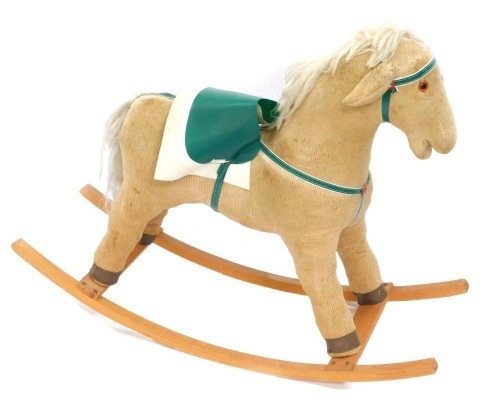 A beige corduroy child's rocking horse.