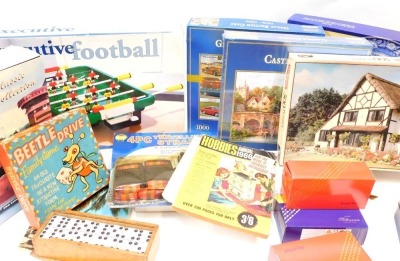 Games and puzzles, including a 1000 piece Gibson's Castle Combe jigsaw, Executive table football, Beetle Drive, Hobbies 1966 Annual, Pastimes English blue and white plate double sided circular jigsaw puzzle, etc. (1 box)