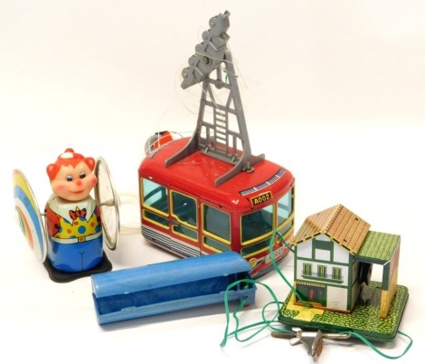 A tinplate cable car set, a tinplate clockwork cat, and a tinplate hut. (3)