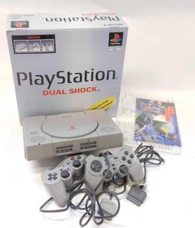 A Playstation model SCPH 7502B, with dual shock controller and accessories, boxed.