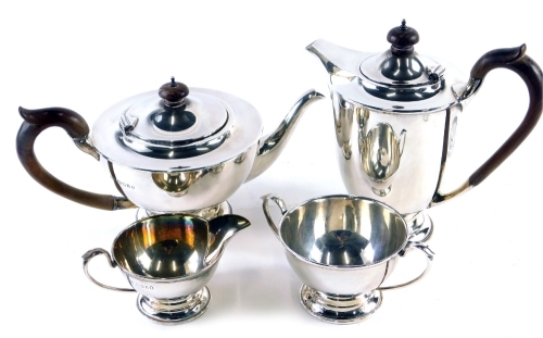 A George V silver four piece tea service, by A W Benson Ltd, comprising water jug, 23cm high, teapot, two handled sugar bowl and milk jug, each of plain form, London 1934, 52oz all in. (4)