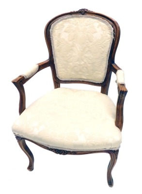 A 20thC French walnut fauteuil, with cream upholstered back, arm rests and seats, on cabriole legs. The upholstery in this lot does not comply with the 1988 (Fire & Fire Furnishing) Regulations, unless sold to a known exporter or upholsterer it will be c