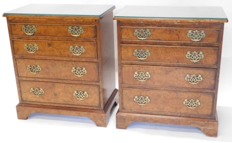 A pair of burr elm veneer bachelor chests, in 18thC style, each with a rectangular top with a boxwood strung and cross banded border, moulded edge and re-entrant corners, above a slide and four graduated drawers, on bracket feet, veneered to the reverse, 