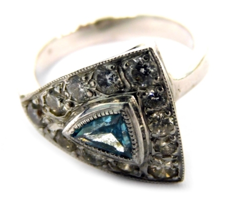 An 18ct white gold dress ring, with triangle shaped design, with a central blue zircon, in rub over setting surrounded by tiny diamonds, on a white metal band, 5.3g all in.