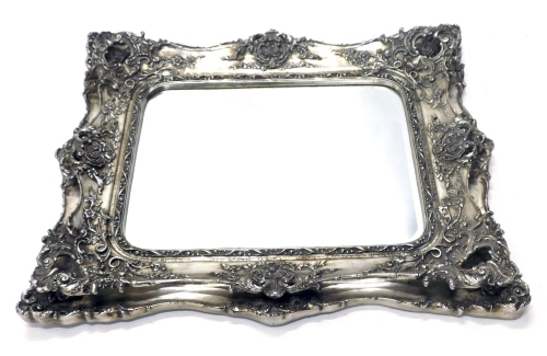 A large silvered rococo style wall mirror, rectangular bevelled plate, the frame decorated with scrolls, leaves, flowers, etc., 121cm high, 100cm wide.