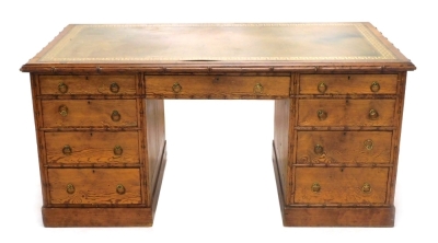 A Victorian pitch pine kneehole desk by A Blain and Son, Liverpool, carved to simulate bamboo, the rectangular top with a green leather inset, decorated in gilt with a Greek key border, supported by two pedestals, each with four graduated drawers with bra