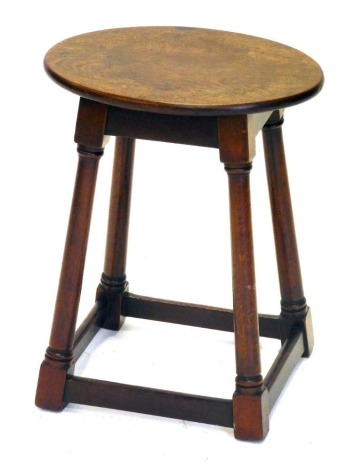 An early 19thC mahogany stool, with oval top, turned legs and stretchers, 42cm high, 33cm oval.