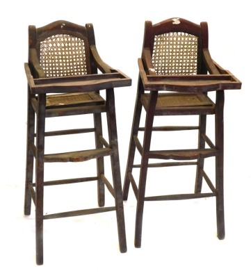 A pair of child's highchairs, with caned backs and seats.