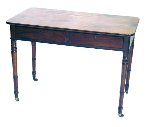 A George III mahogany side table, with rounded rectangular top, two frieze drawers, turned legs, and brass cup castors, 100cm wide, 56cm deep.