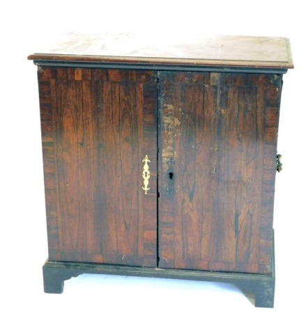 An early 19thC mahogany and rosewood collectors cabinet, with two cross banded doors (AF), 90cm high, 87cm wide, 46cm deep.