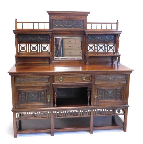 A 19thC aesthetic rosewood sideboard, in the manner of Lamb of Manchester, with central bevel glass surmounted by a raised metal work garland decoration, with carved floral patera above two shelves, single drawer and opening, flanked by further drawers an