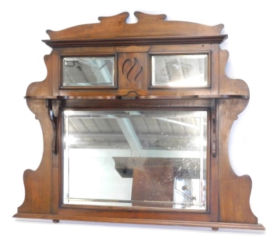 A late 19th/early 20thC walnut overmantel mirror, with a shaped cornice above two bevel mirror plates and a shelf, the larger bevel plate flanked by shaped sides, 109cm high, 129cm wide.