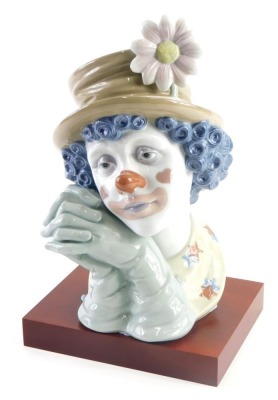 A Lladro bust of a clown, on wooden base, 31cm high. (AF)